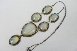 An early 20th century white metal and moonstone style pendant necklace comprising six cabochon