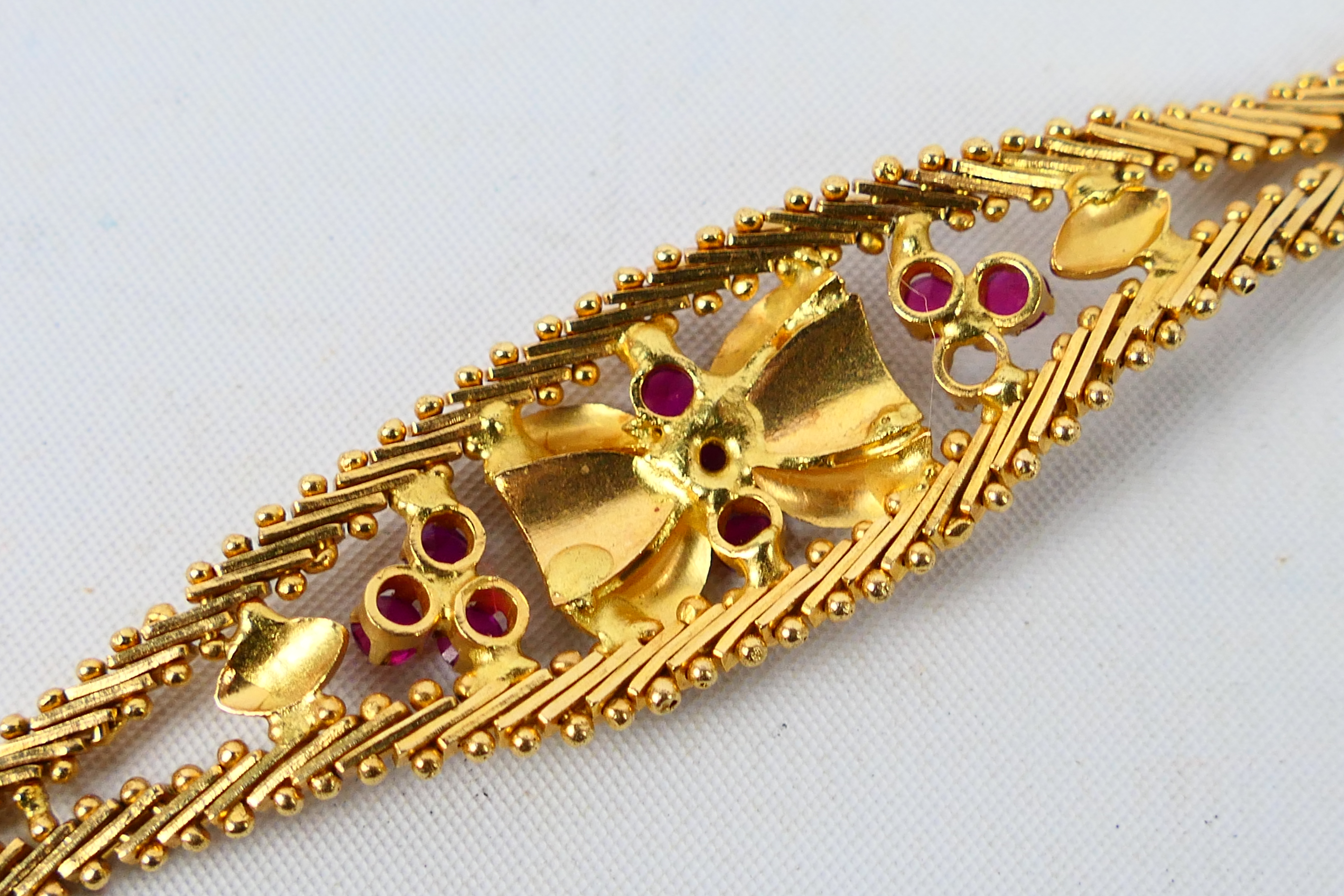 A yellow metal bracelet set with rubies (one stone lacking), stamped 750 and assessed as 18ct, - Image 5 of 6