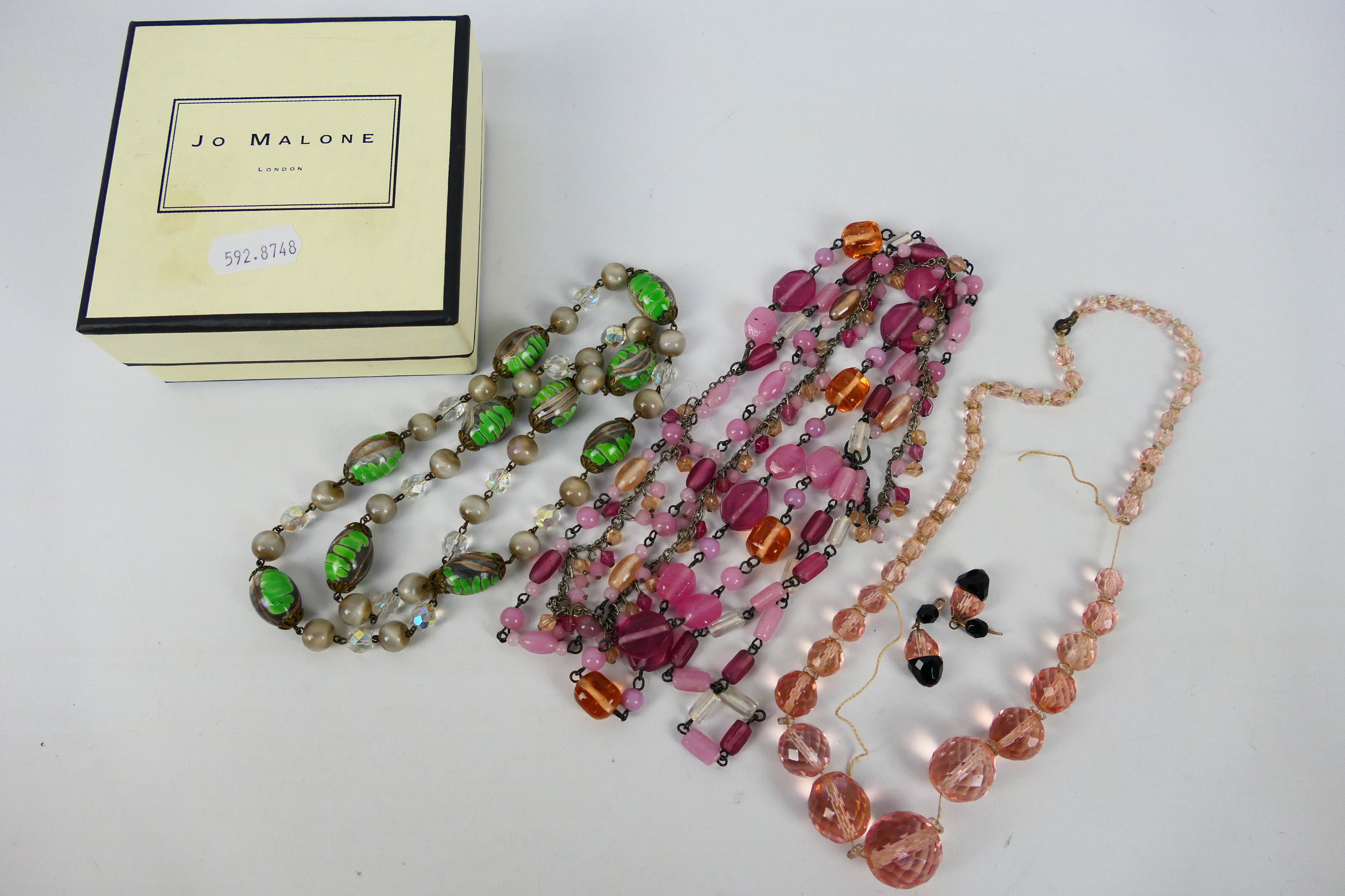 Three decorative costume jewellery necklaces and a pair of earrings.