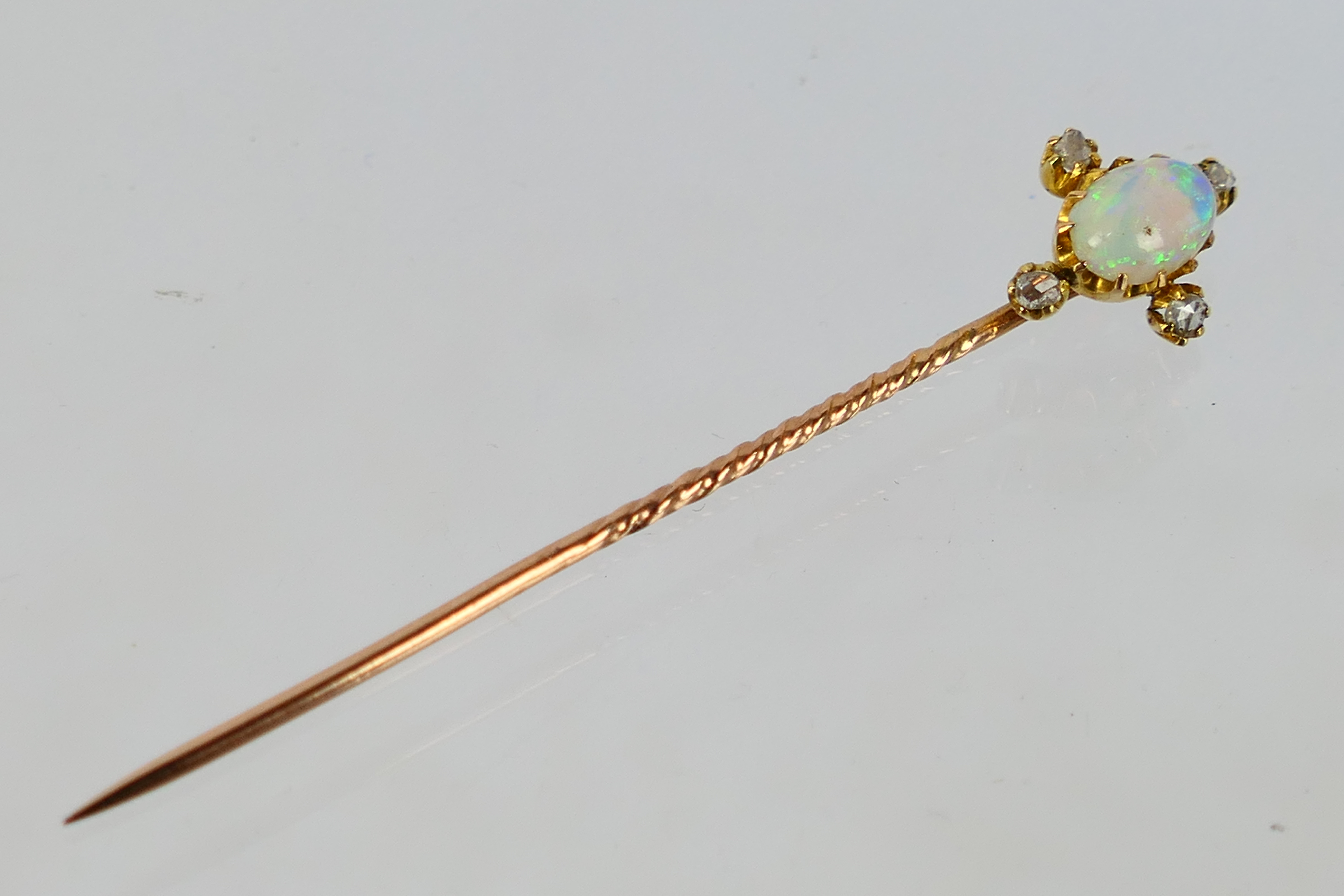 An Edwardian white opal and diamond stick pin contained in fitted case, 1.3 grams.