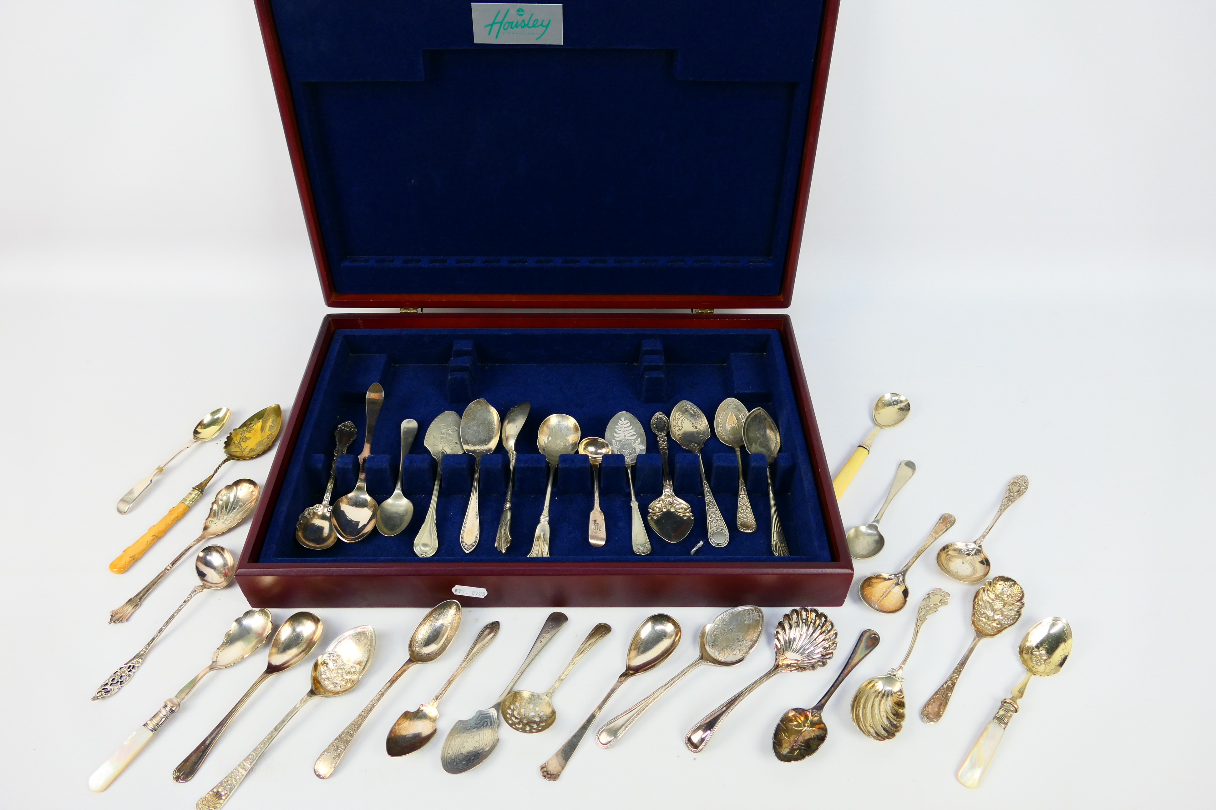 A collection of various plated spoons / serving items, contained in canteen.