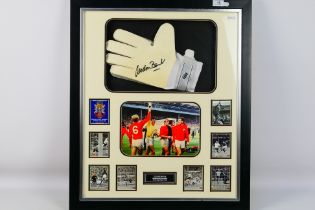 Gordon Banks - A framed display montage comprising a goalkeeper's glove signed by World Cup winner