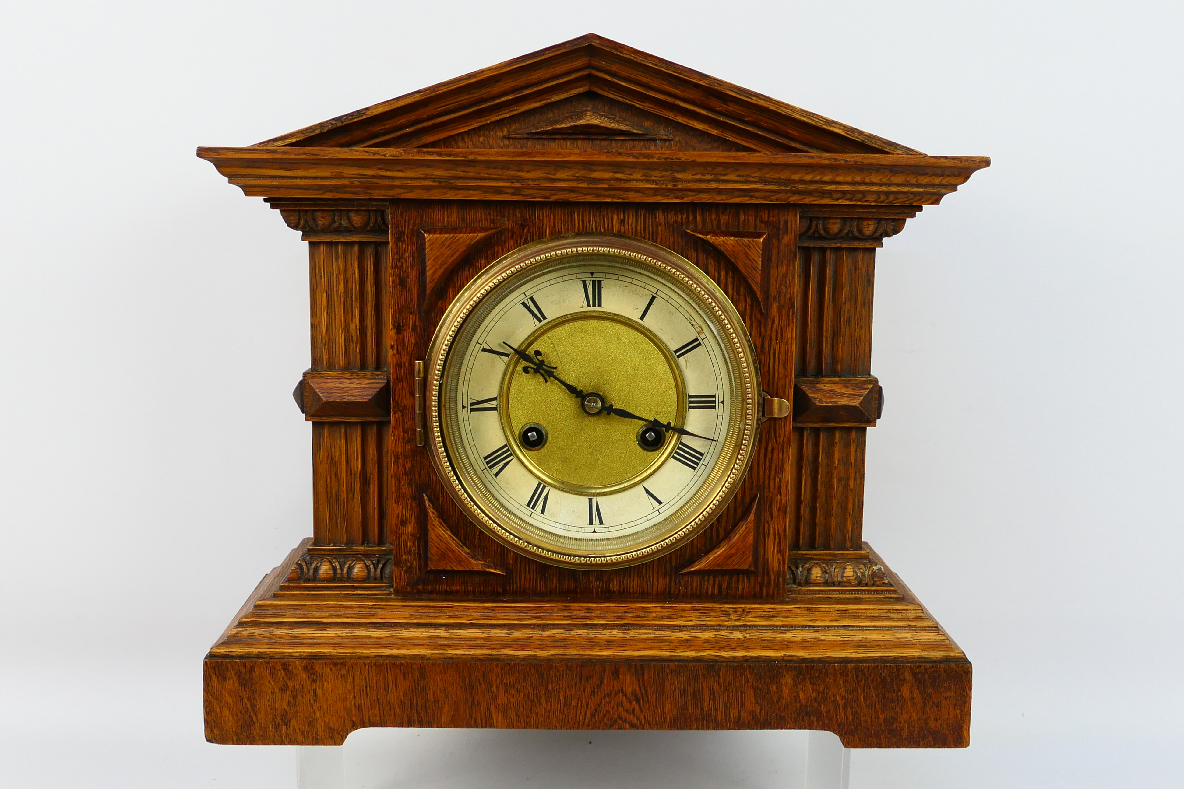 An early 20th century oak cased mantel clock of architectural form,