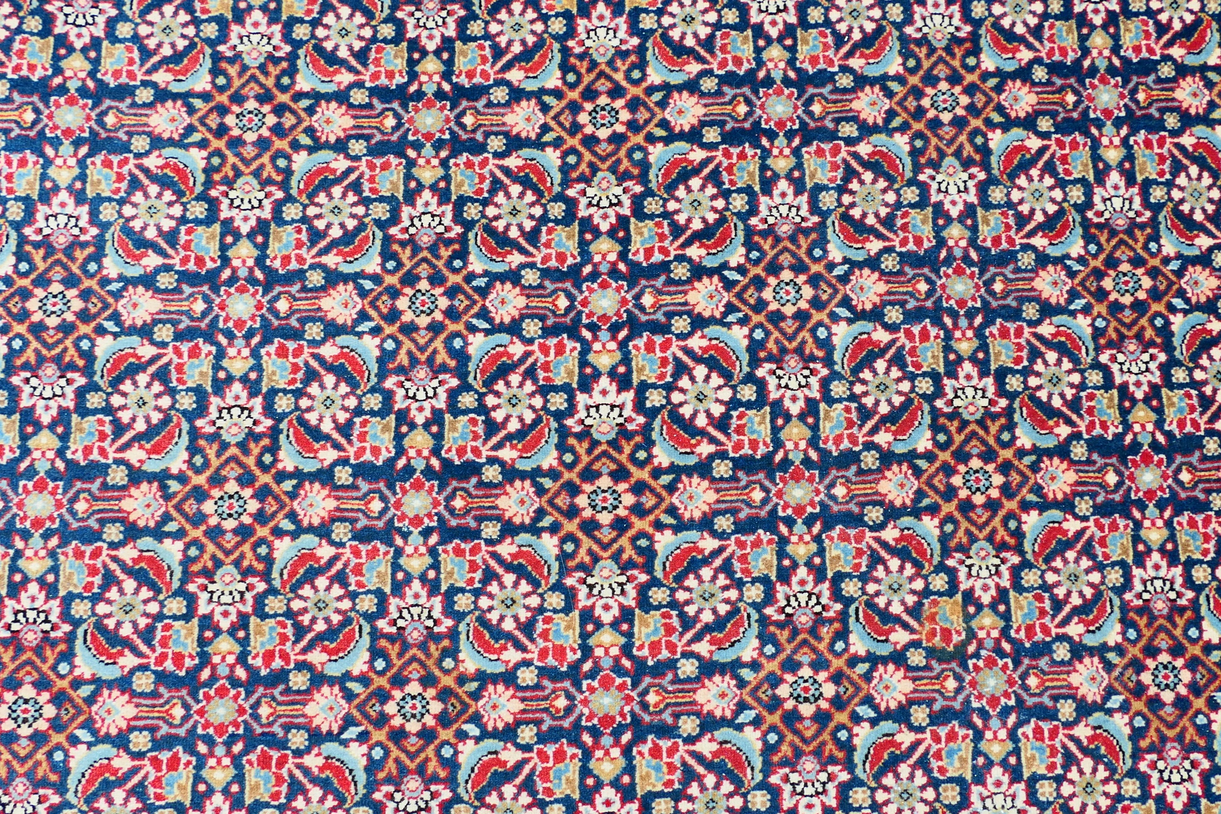 A Persian rug with central blue field with all over polychrome floral decoration within repeating - Image 3 of 6