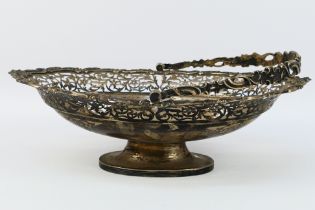 An Edward VII silver fruit bowl with embossed and pierced floral scroll decoration, swing handle,