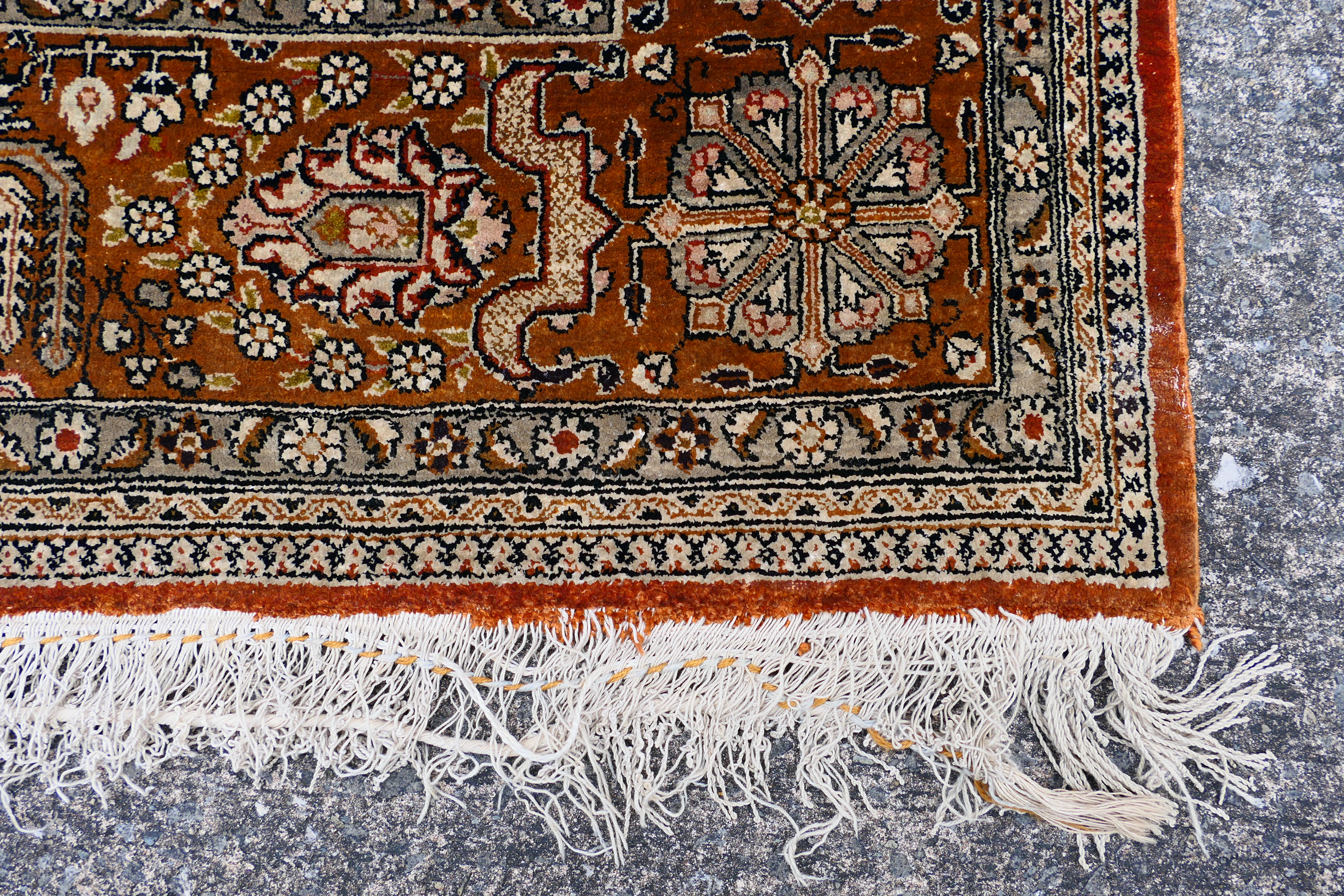 A Persian rug decorated with panels of flowering urns, - Image 9 of 17