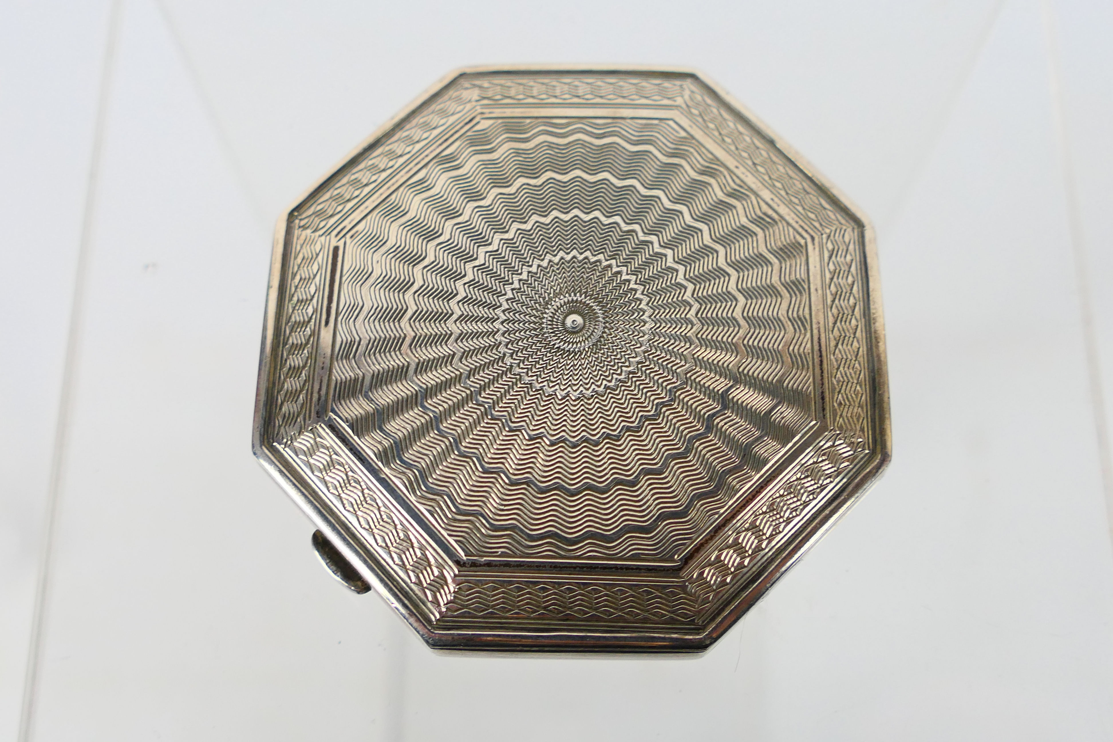 A silver powder compact of octagonal form having engine turned decoration to the cover,