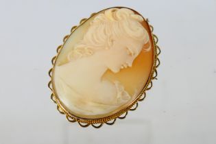 A yellow metal cameo brooch, stamped 9ct, 5 cm (l), with profile portrait of a lady,