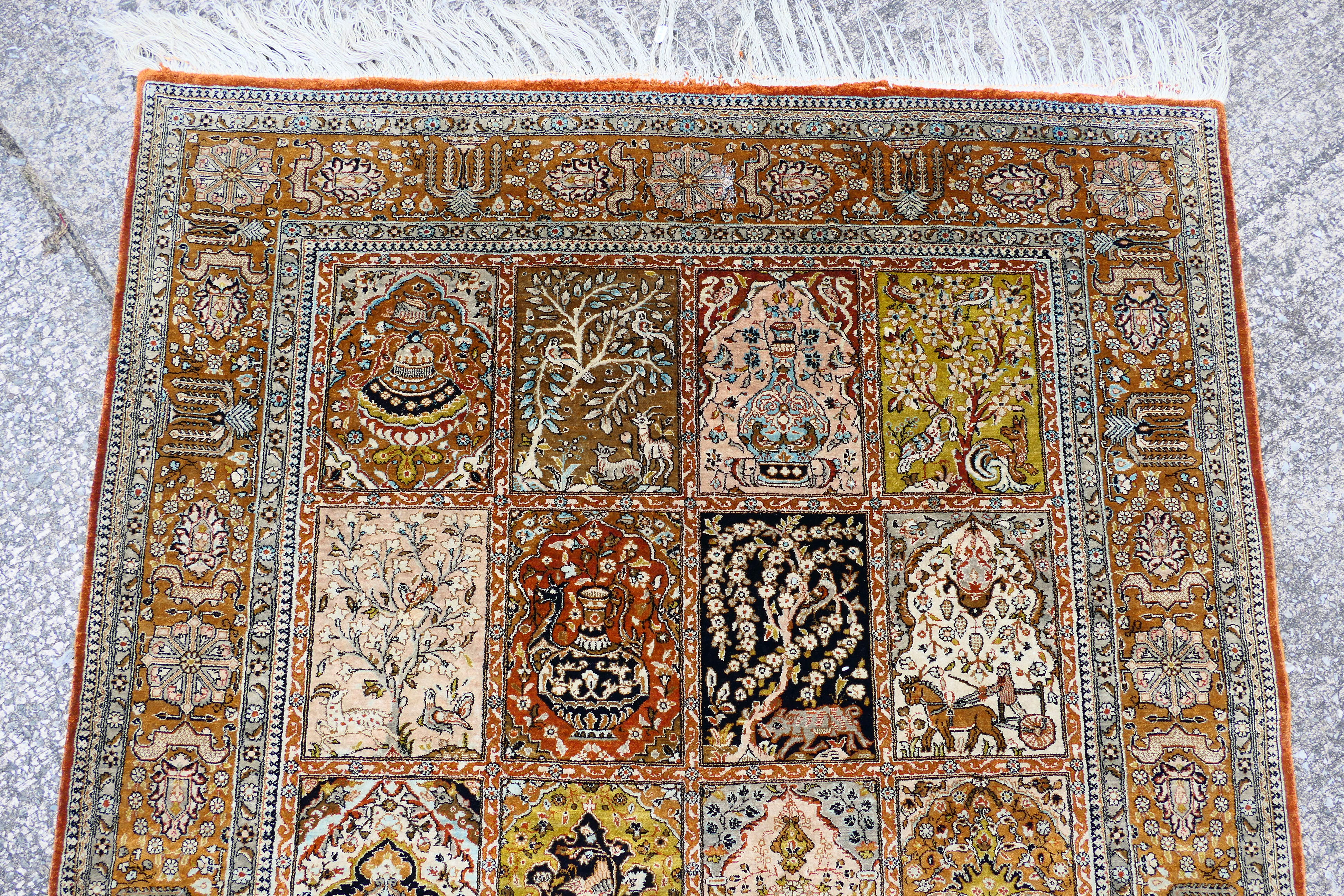 A Persian rug decorated with panels of flowering urns, - Image 4 of 17