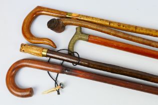 Five walking sticks / staffs, largest approximately 135 cm (l).