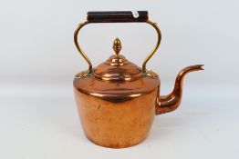An antique copper kettle with acorn finial to the cover.