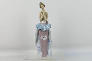 A large Lladro figure, # 6592, An Expression Of Love, depicting a young lady holding flowers,