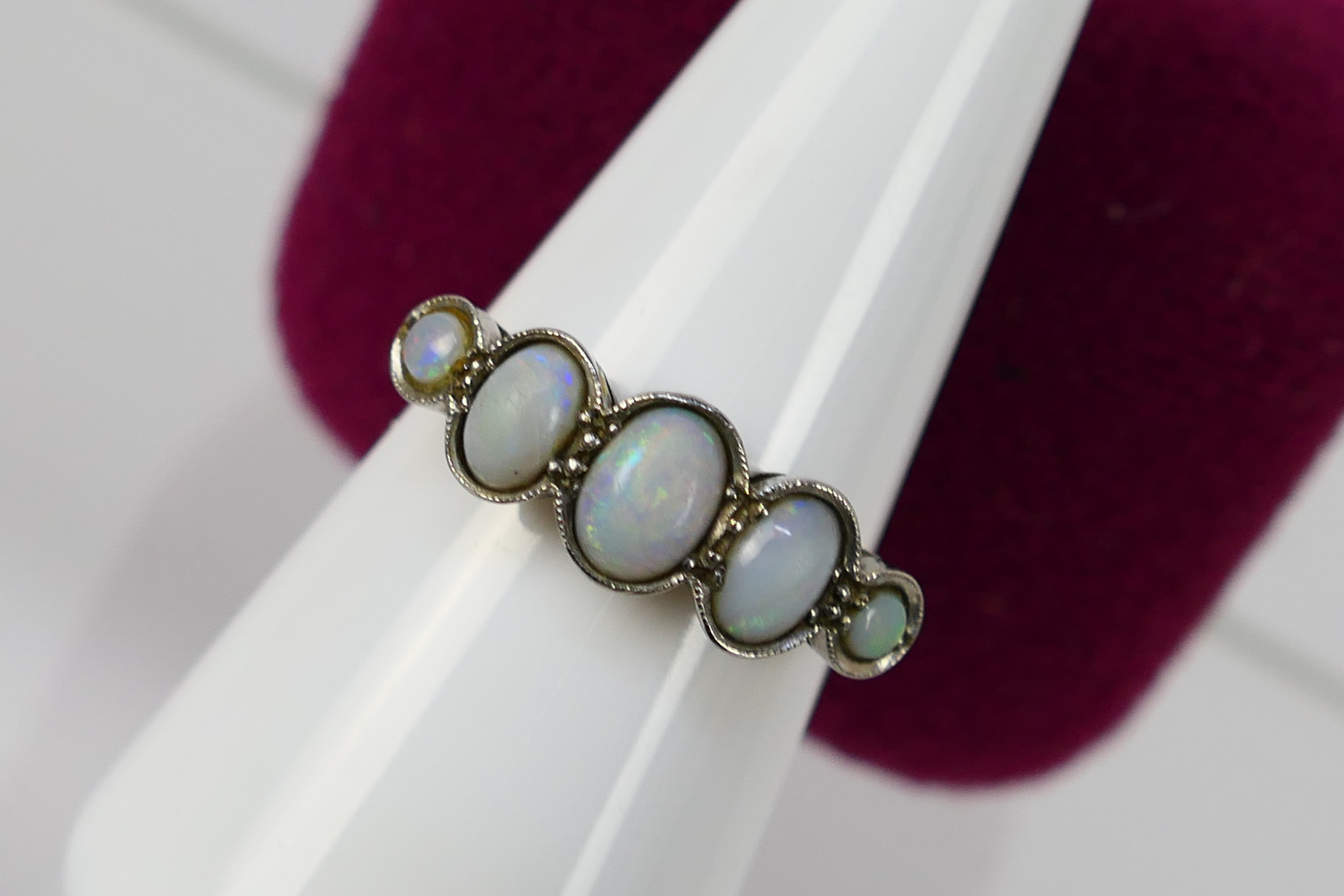 A five stone opal ring, stamped 18ct PLAT, size N+½, 3.2 grams.