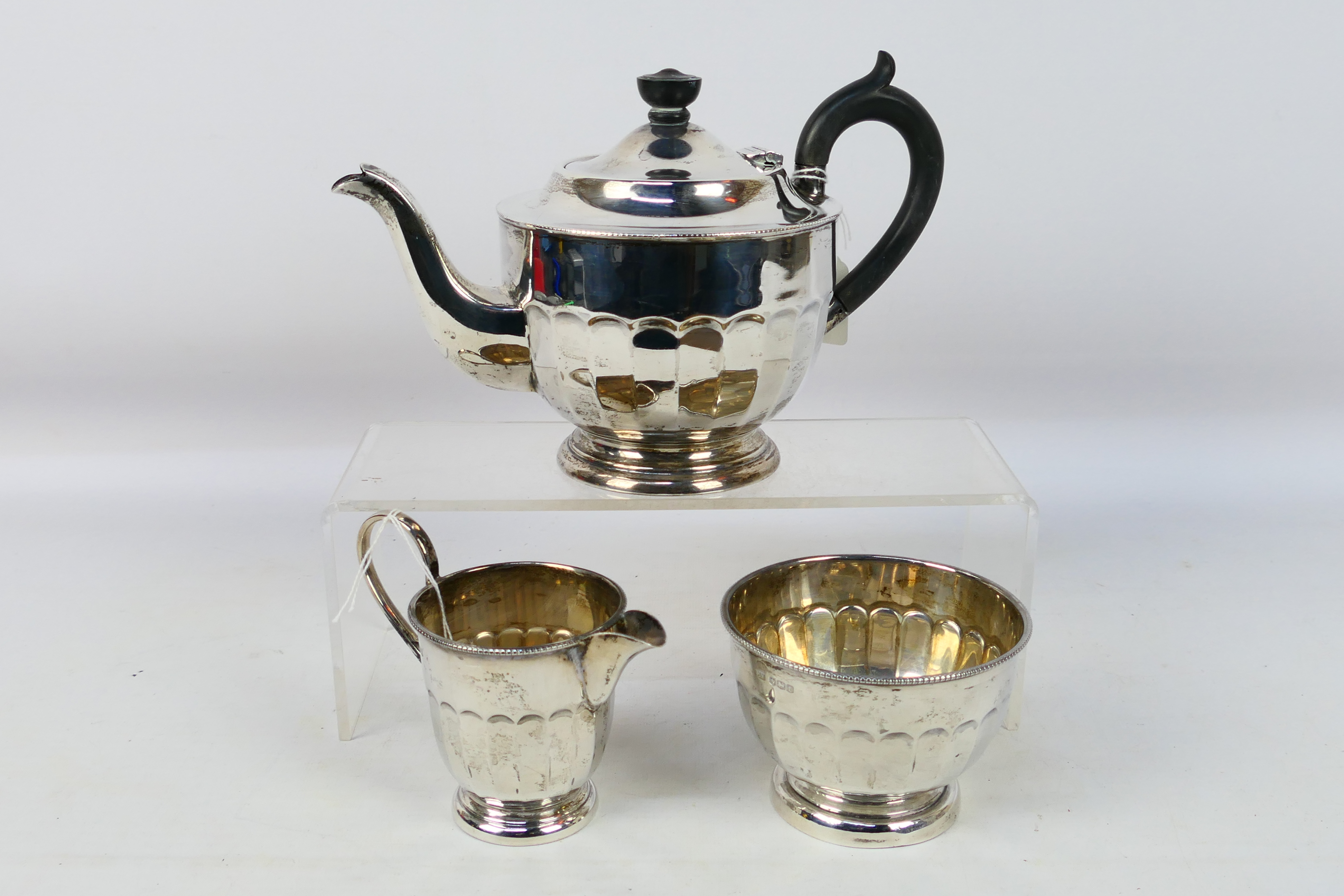 A silver tea service comprising teapot, sugar bowl and milk jug, Sheffield assay 1936,