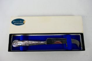 A silver handled cheese knife in original box. Sheffield assay 1983. Harrison Brothers makers mark.