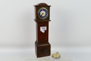 A vintage mantel or desk clock in the form of a longcase clock,
