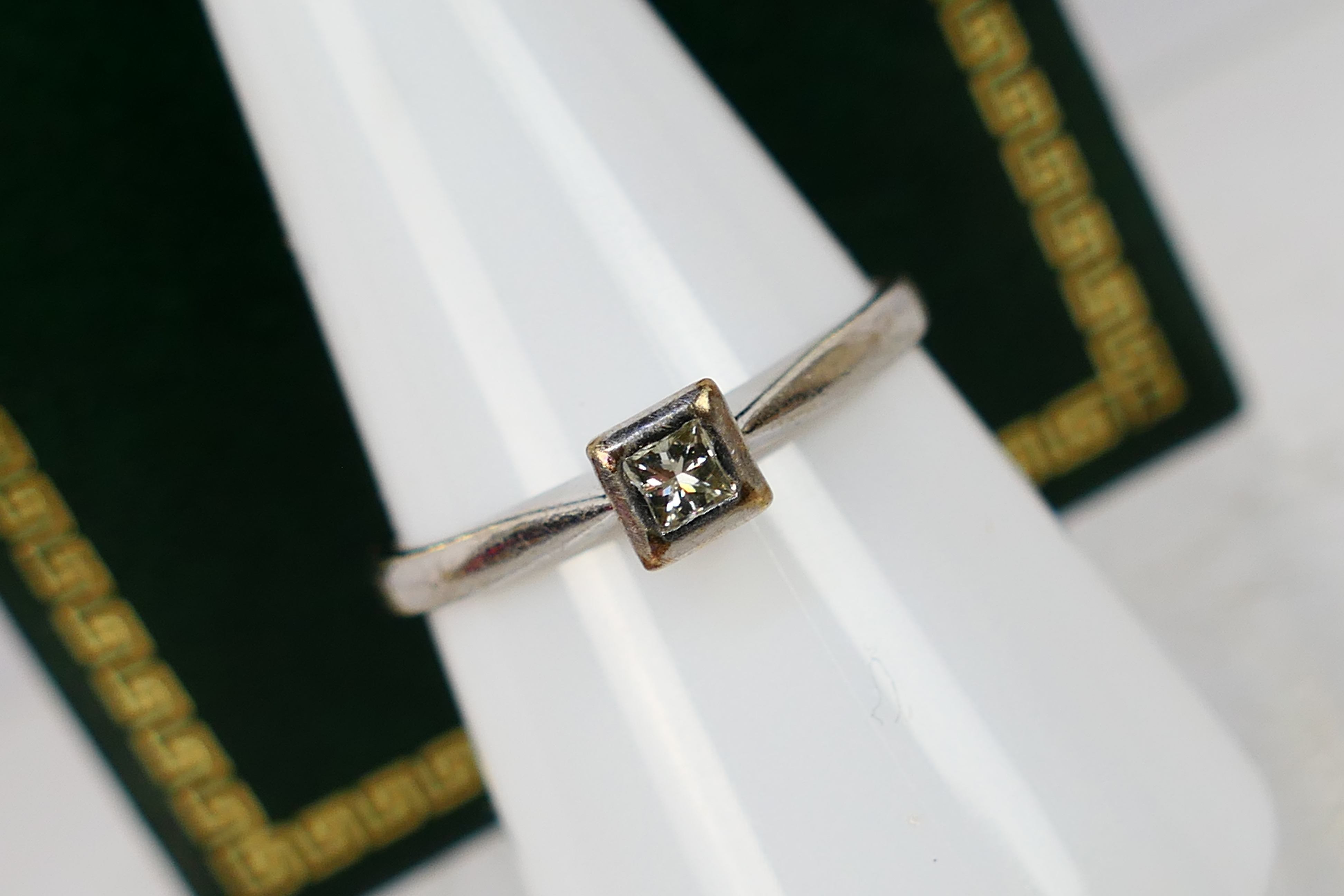 A 9ct white gold diamond solitaire ring, set with a 10 point stone, size O+½, approximately 2 grams.