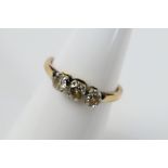 A yellow metal diamond trilogy ring comprising old cut stones, stamped 18ct,