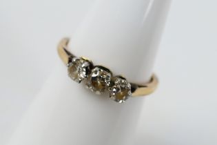 A yellow metal diamond trilogy ring comprising old cut stones, stamped 18ct,