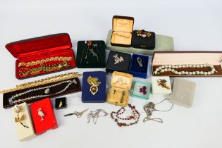 A collection of costume jewellery to include brooches, necklaces, stick pins and other,