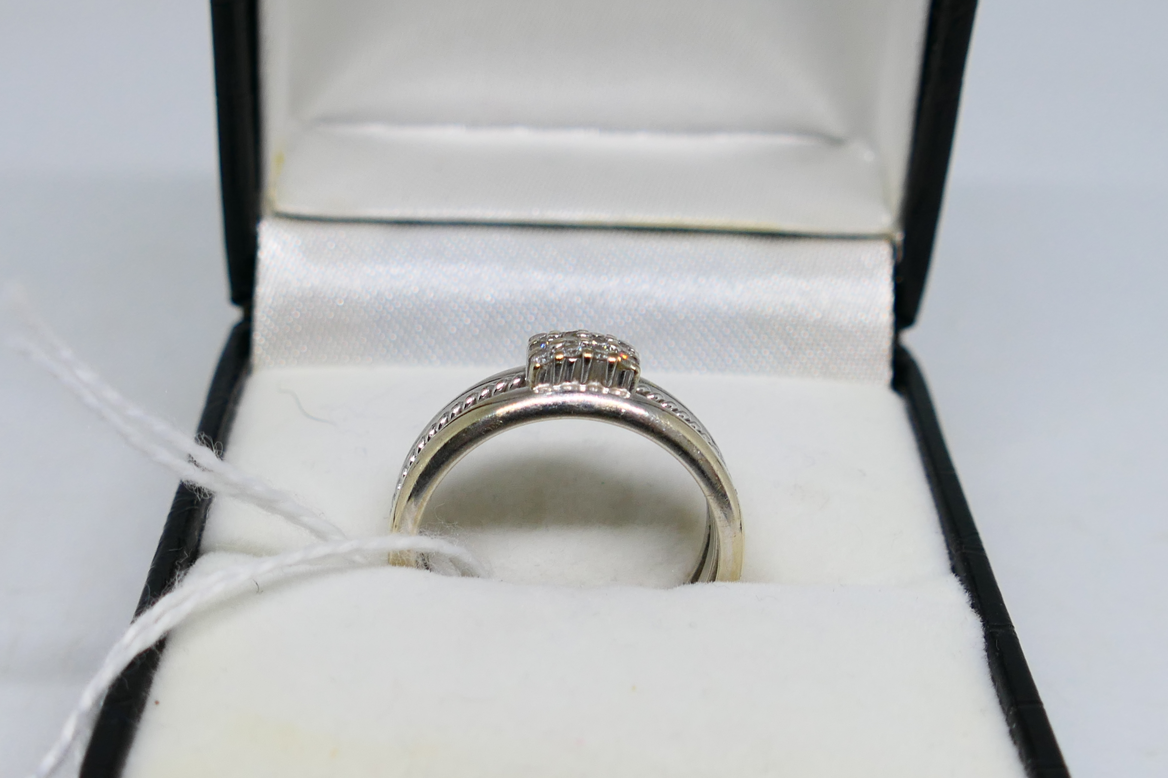 A white metal ring (assessed as 9ct) set with twelve small diamonds, size P, approximately 7. - Image 2 of 6