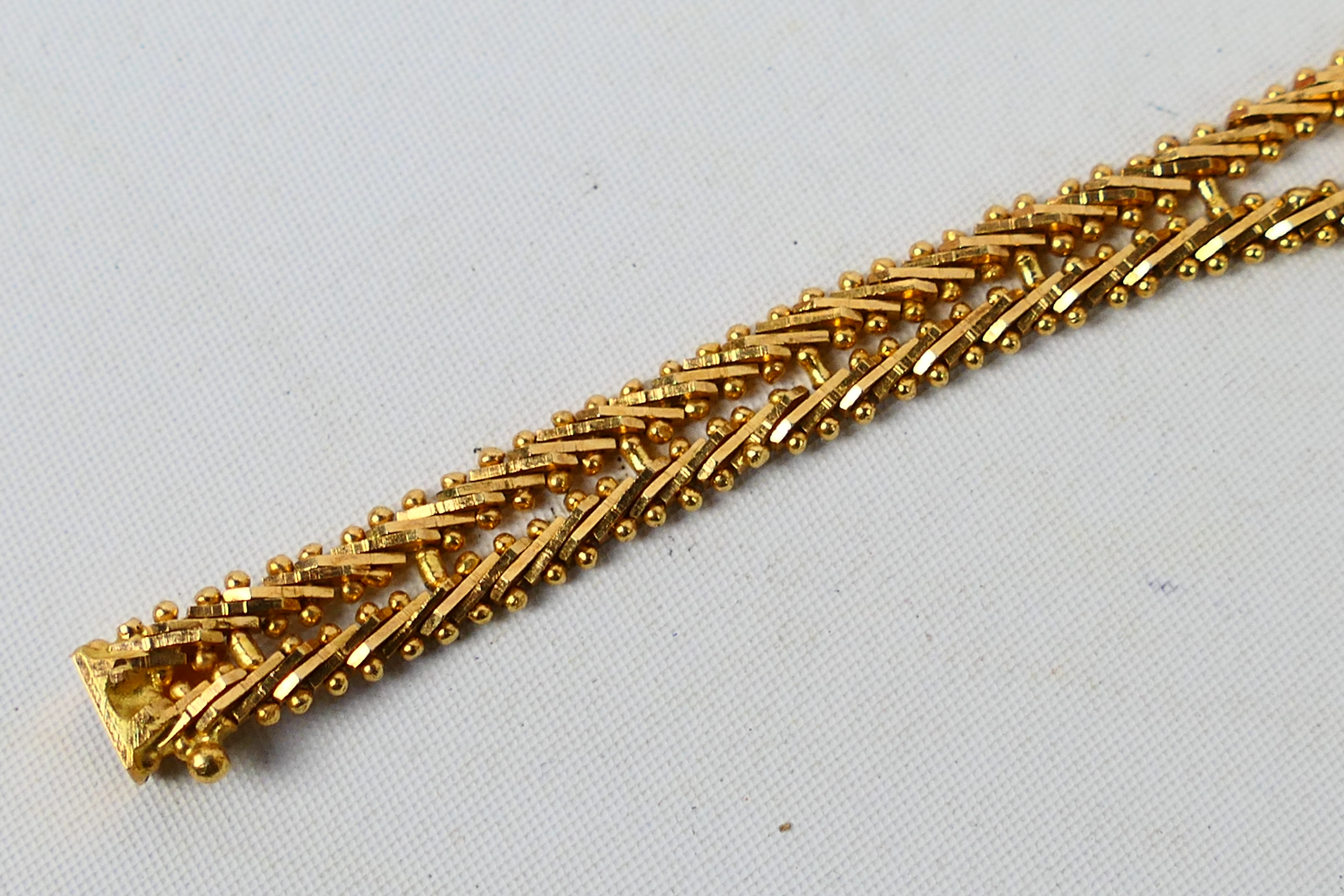 A yellow metal bracelet set with rubies (one stone lacking), stamped 750 and assessed as 18ct, - Image 4 of 6