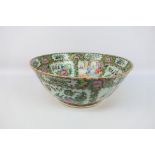 A large Cantonese famille rose punch bowl, typically decorated with panels of figures and flora,