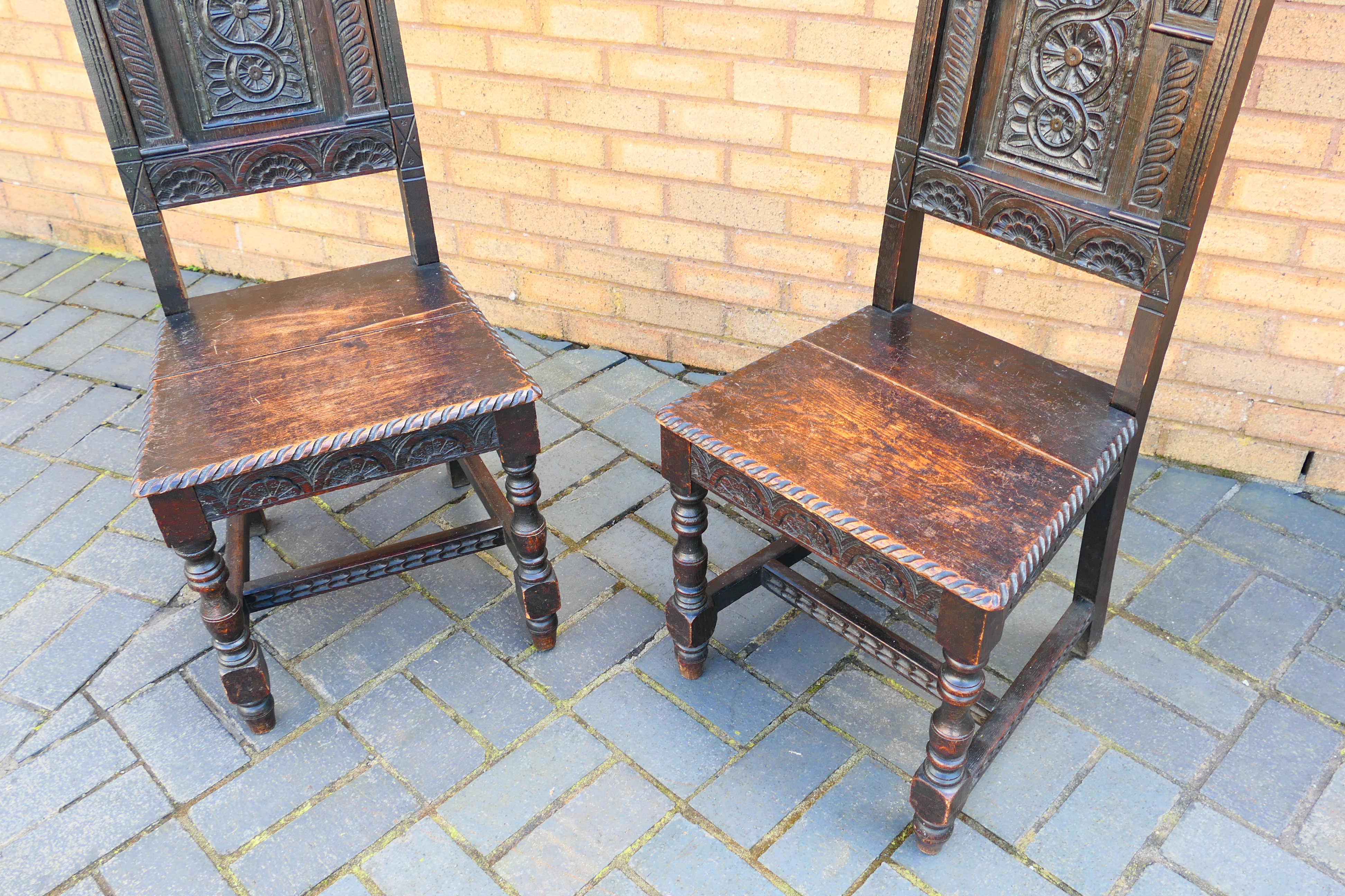 An antique pair of highly carved oak hall chairs. [2]. - Image 2 of 6