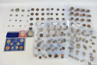 A collection of British and foreign coins contained in coin sleeve sheets, Victorian and later,