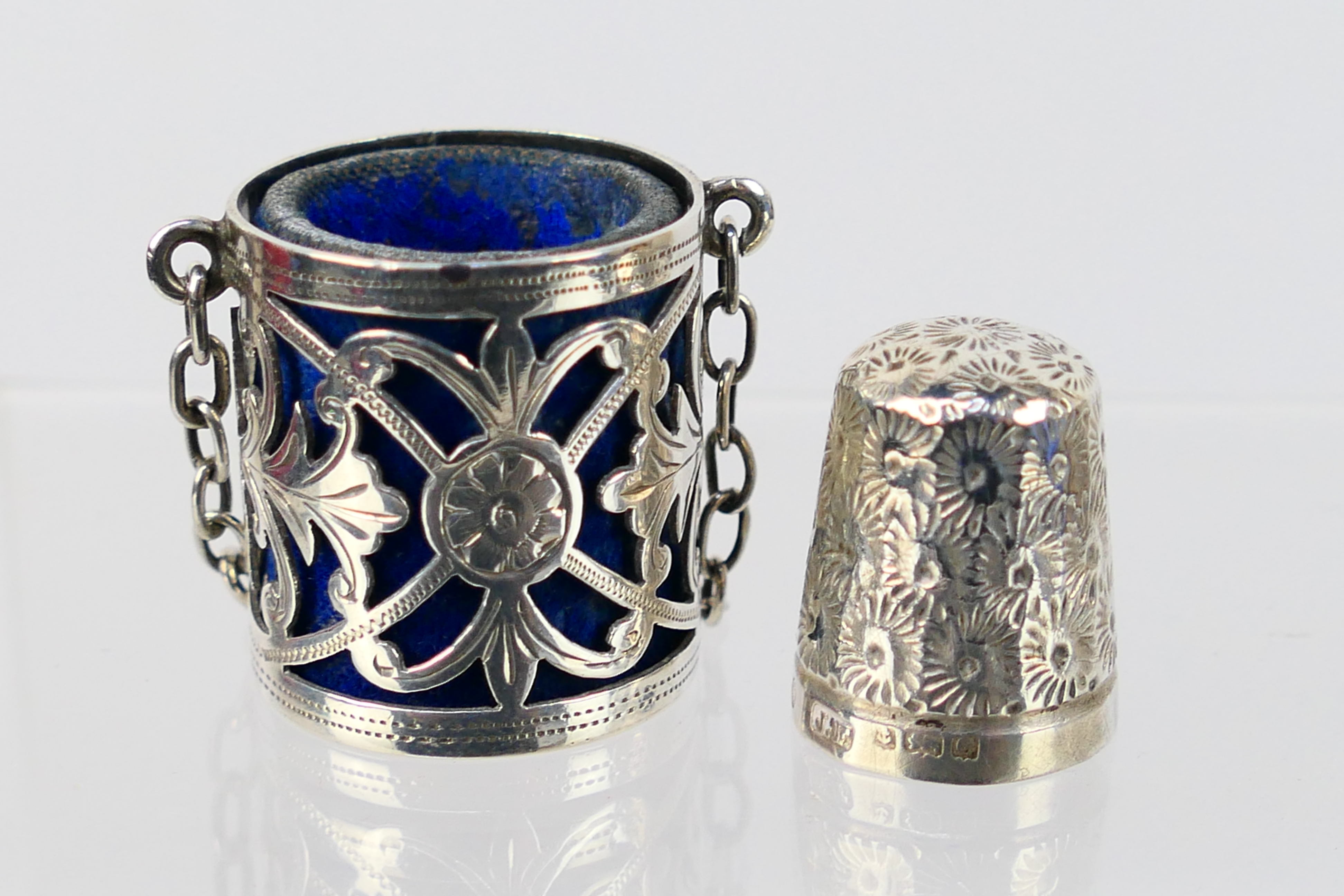 An Edwardian silver chatelaine thimble case with pierced and chased decoraction,