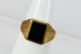 A 9ct yellow gold and onyx signet ring, size R, 3.1 grams.