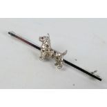 A white metal bar brooch, stamped 14ct, in the form of a terrier,