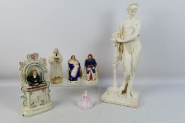 A collection of Staffordshire and other to include a Wesley clock and a large plaster figure,