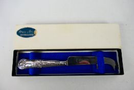 A silver handled cheese knife in origina