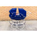 Silver Cross - A blue Silver Cross pram containing two dolls.