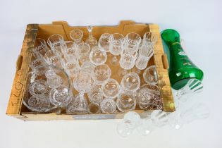 A collection of crystal glassware and a green glass jug with hand painted floral decoration.