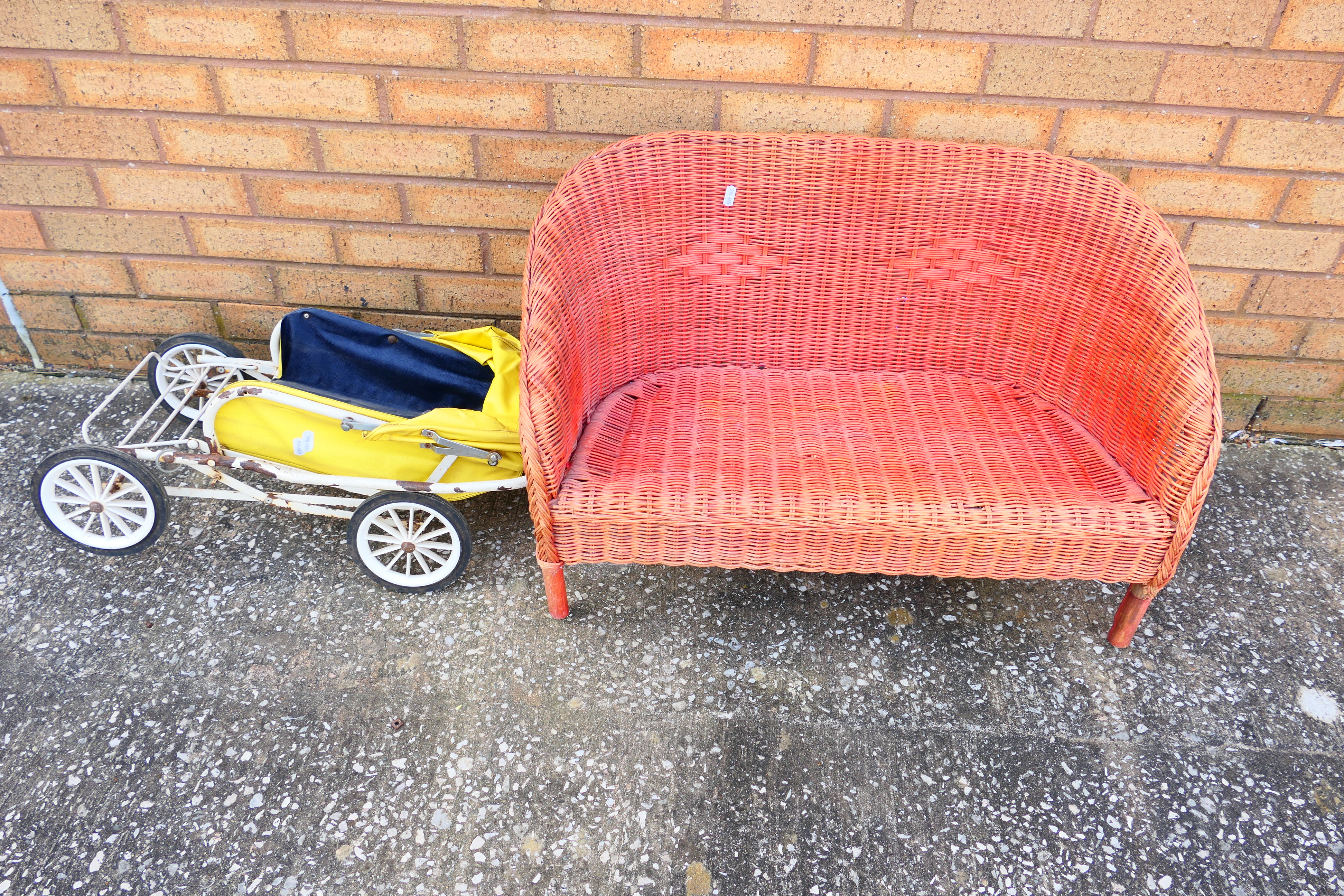 A vintage children's toy pram together with a vintage children's wicker settee.