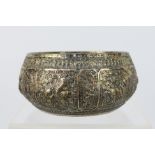 An Asian white metal bowl with all over repousse decoration of fauna and foliate scrollwork,