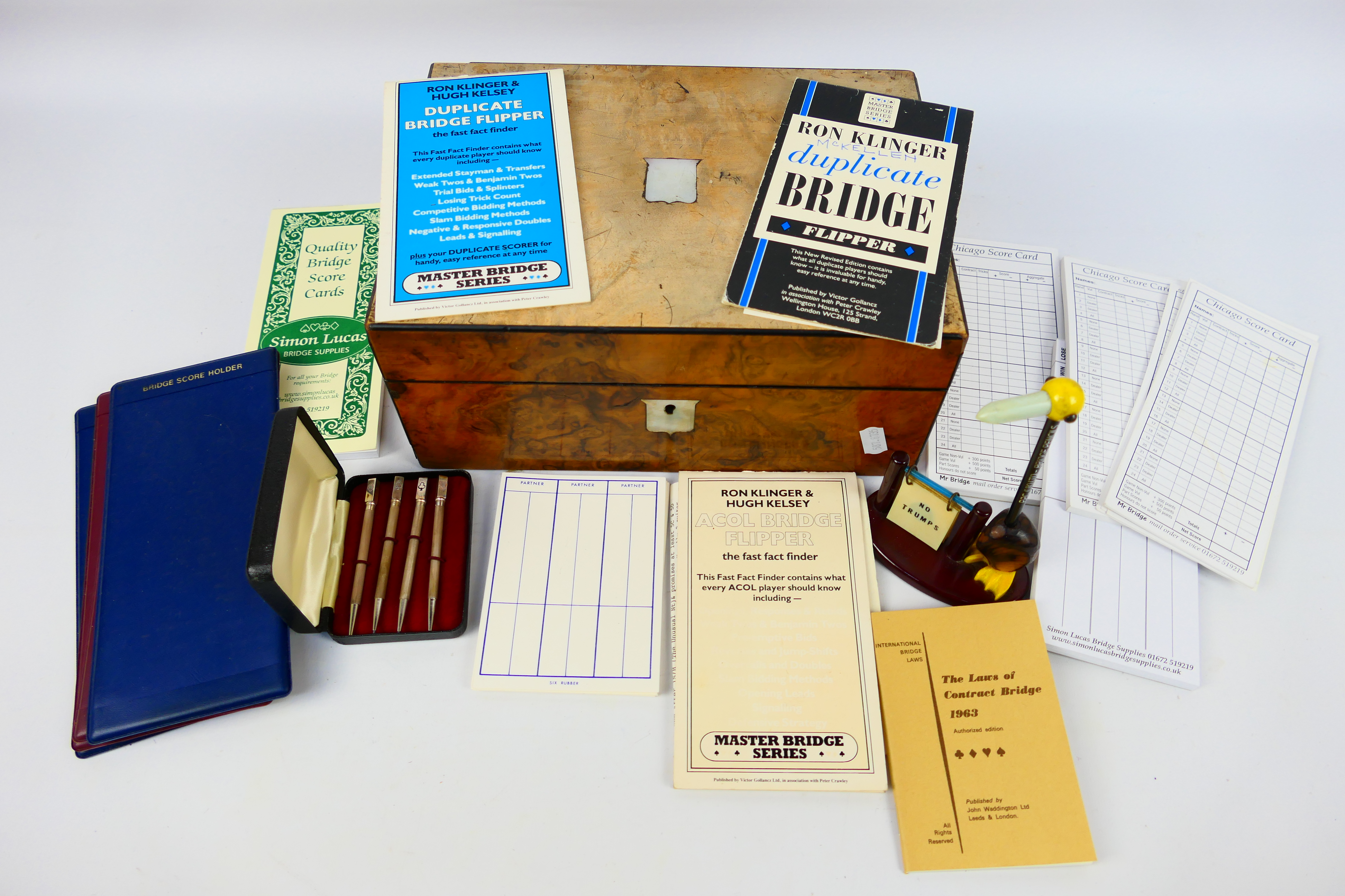 A wooden box containing bridge score cards and similar to include a set of four propelling pencils