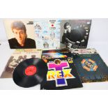 A collection of 12" vinyl records to include Rolling Stones, Queen, ELO, John Lennon,