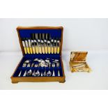 A silver plated/stainless steel cutlery set presented in a wooden presentation box.