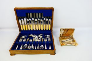A silver plated/stainless steel cutlery set presented in a wooden presentation box.