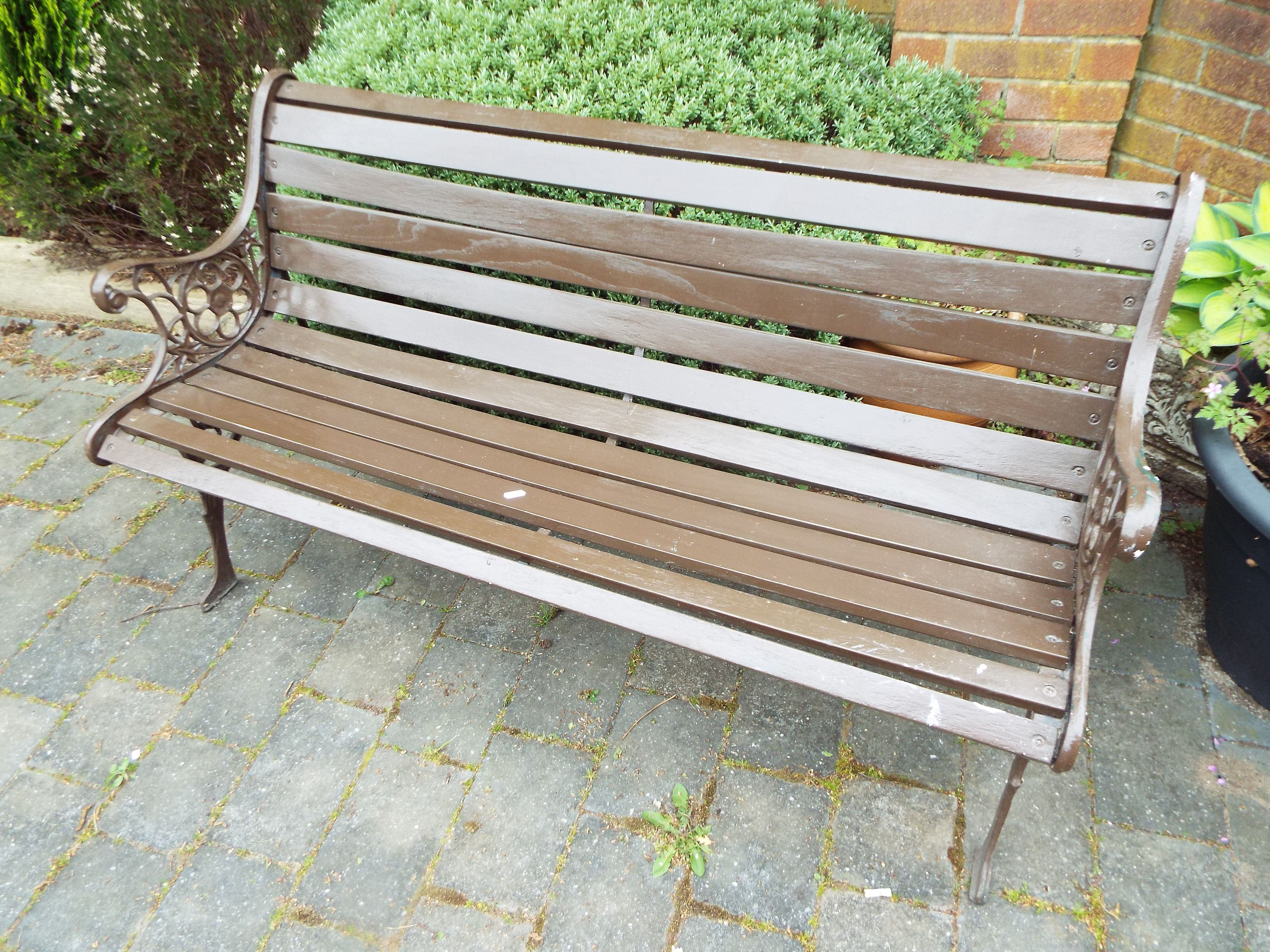 A two seat garden bench with slatted seat and combined back raised on cast iron scroll pattern - Image 2 of 2