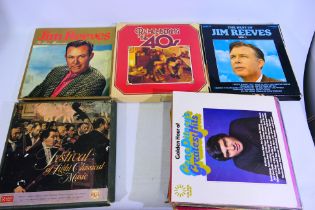 A collection of 12" vinyl records to include Jim Reeves, Elvis Presley Greatest Hits, Abba,