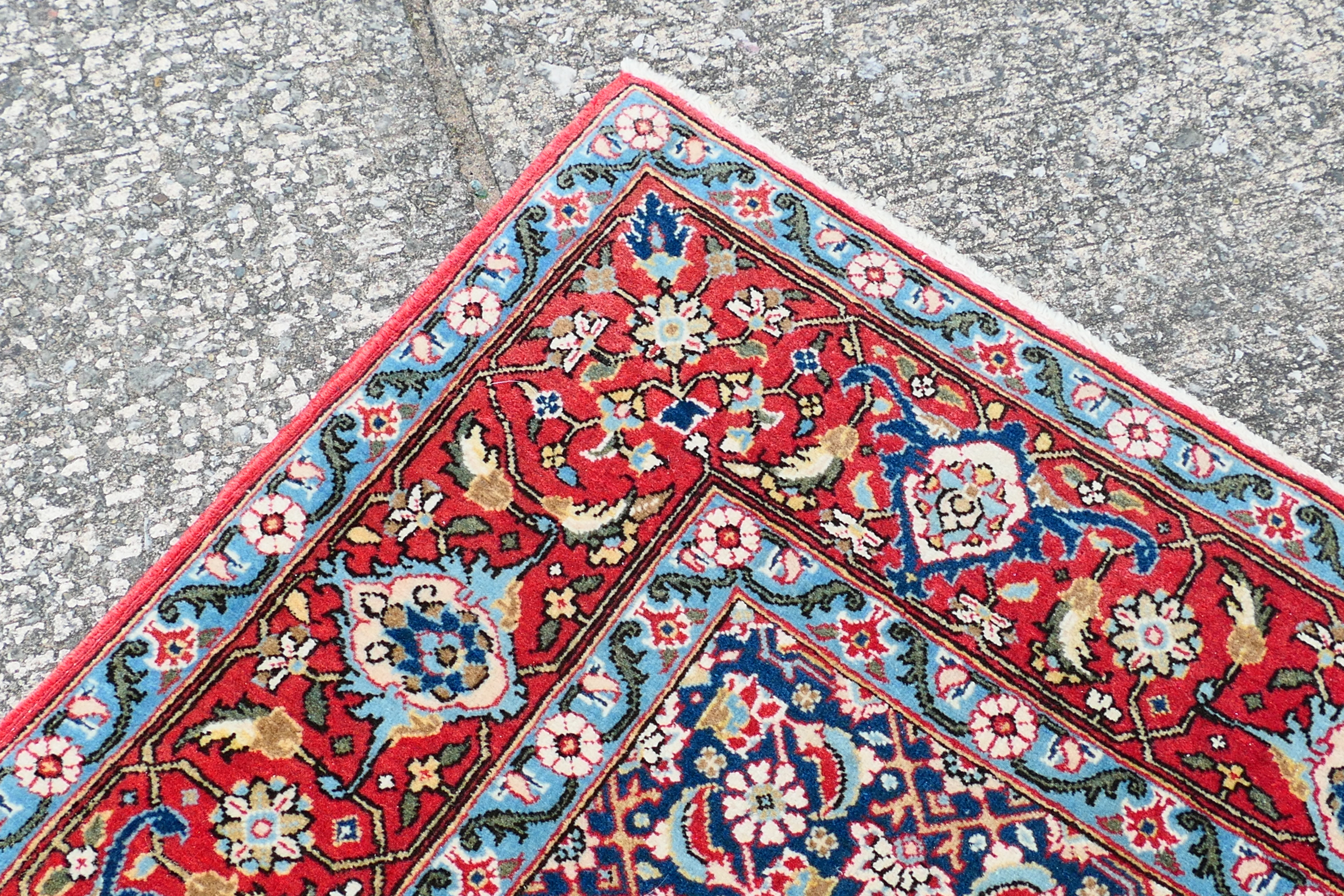 A Persian rug with central blue field with all over polychrome floral decoration within repeating - Image 4 of 6