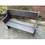 A garden bench seat with pegged plant sides and wide slatted seat and back, the whole painted brown,
