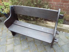 A garden bench seat with pegged plant sides and wide slatted seat and back, the whole painted brown,