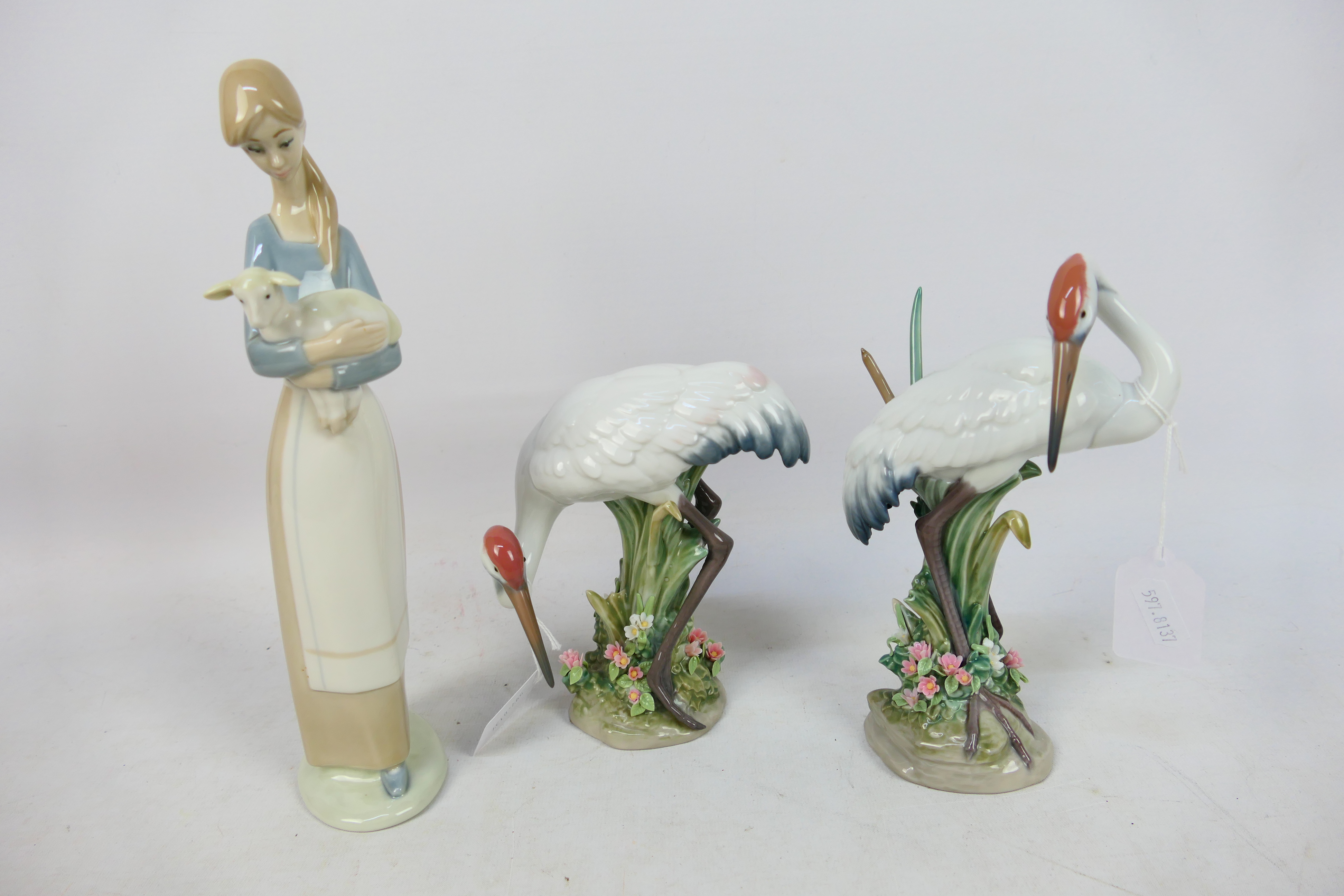 Lladro - Three figures comprising two Red-crowned crane studies and a girl carrying a lamb,