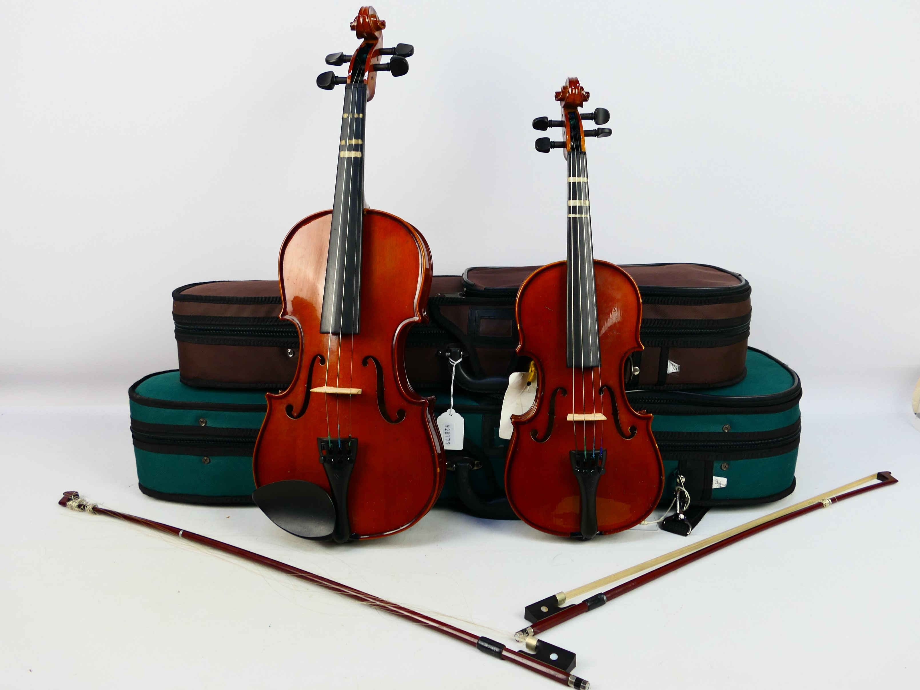 Two cased violins comprising two Stentor Student ST, both with bows and contained in carry cases.