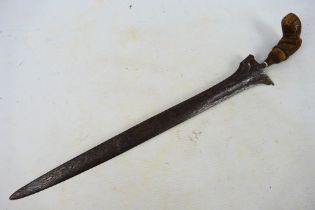 A late 19th or early 20th century Indonesian kris, 39 cm (l) blade and shaped carved hilt.